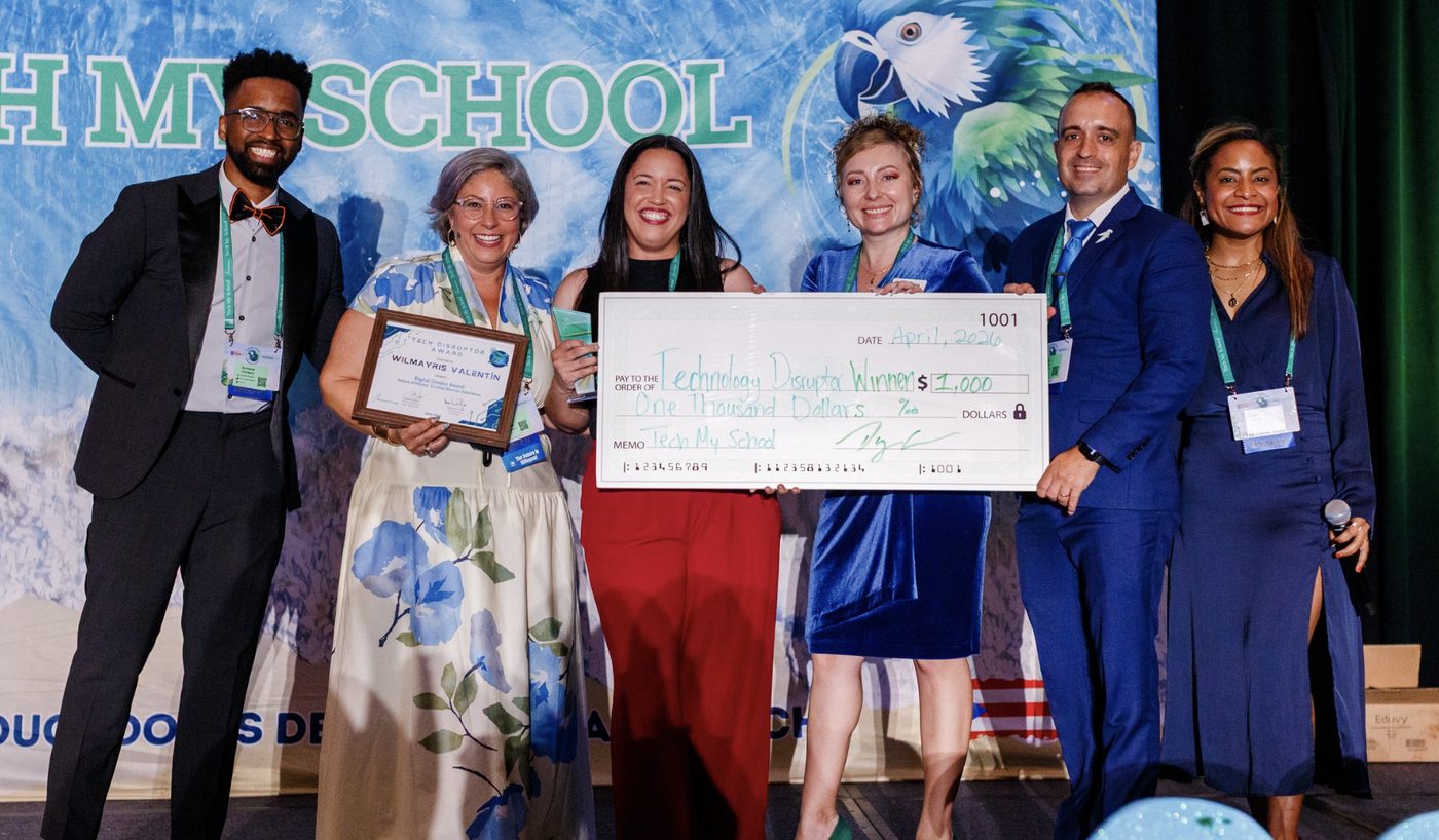 A Tech Disruptor winner accepting a $1,000 check and award on stage