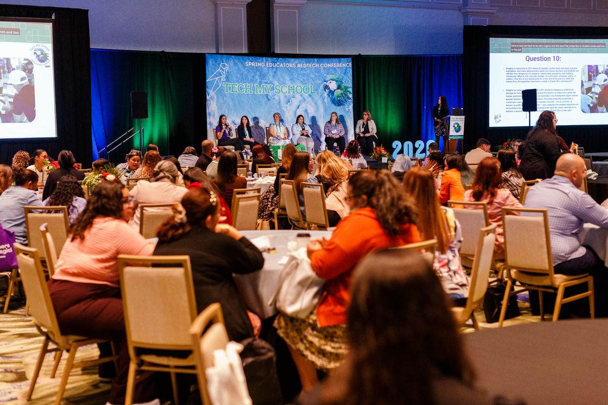A leadership panel in front of a full ballroom